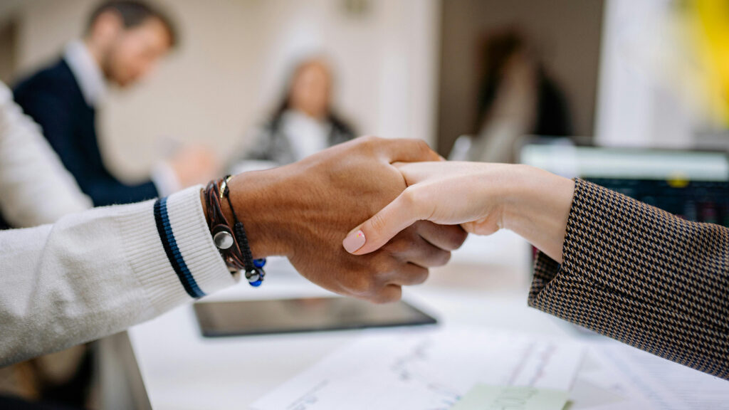 Professioneller Händedruck in einem Büro, symbolisierend Business-Partnerschaft und erfolgreiche Zusammenarbeit